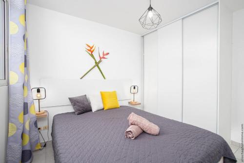ein Schlafzimmer mit einem Bett und einem rosa Handtuch darauf in der Unterkunft Navira Appartement Bleu Nuit in Quartier Châteauboeuf