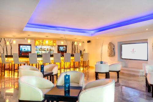 a waiting room with white chairs and a flat screen tv at Flamingo Cancun All Inclusive in Cancún