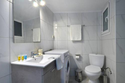a white bathroom with a toilet and a sink at Plaka, Apartment in the old historical neighborhood of Athens in Athens
