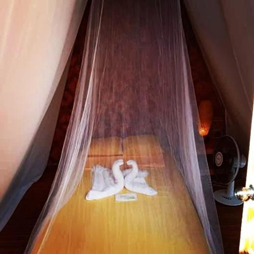 a bed with white towels and a canopy at SHUKRAN Apartelle in Siquijor