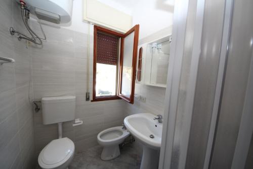 a small bathroom with a toilet and a sink at Villa Debby appartamento 01 in Rosolina Mare