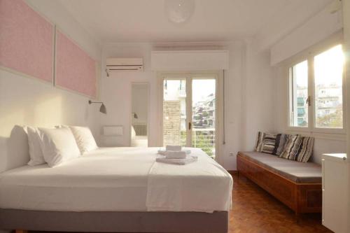 Thiseio, a vintage apartment في أثينا: غرفة نوم بيضاء مع سرير كبير وأريكة