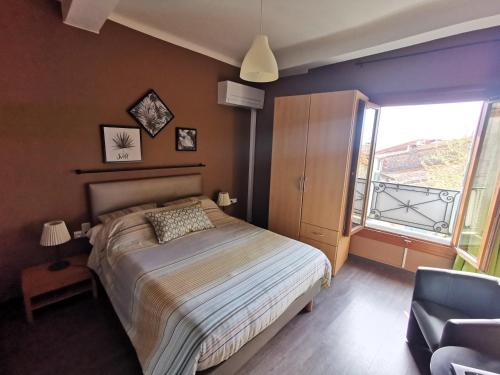 1 dormitorio con 1 cama, 1 silla y 1 ventana en Au Remp'Arts en Elne