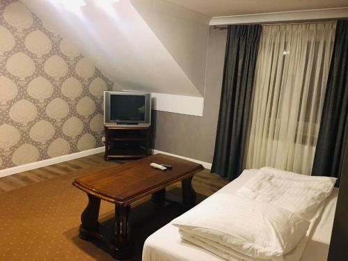um quarto com uma cama, uma televisão e uma mesa em Hostel LaGoya z Restauracją em Nielisz