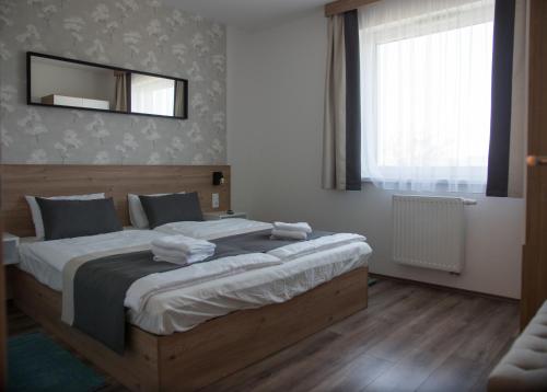 1 dormitorio con 1 cama grande y espejo en la pared en Lelle Resort B26, en Balatonlelle