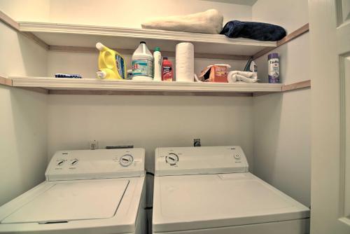 a small bathroom with two white washers and shelves at Fish at Canalfront Bay St Louis Home - Dock and Deck in Shoreline Park