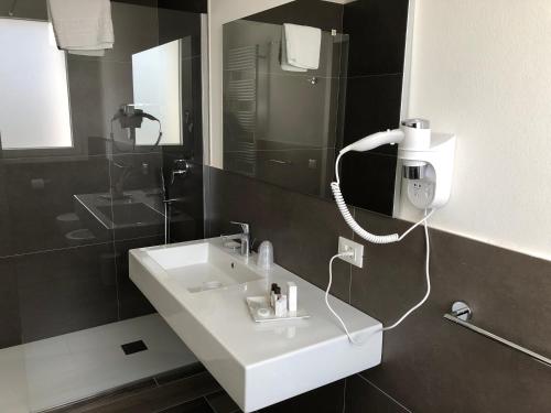 a bathroom with a sink and a phone on the wall at B&B Alma Garda Lake in Peschiera del Garda