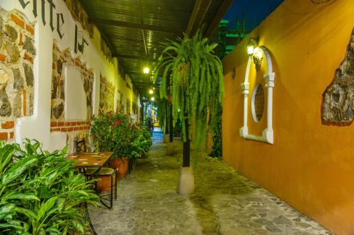 a hallway with plants and tables in a building at Posada San Vicente by AHS in Antigua Guatemala