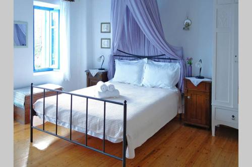 a bedroom with a large bed with a canopy at Chariklia Traditional House in Alonnisos