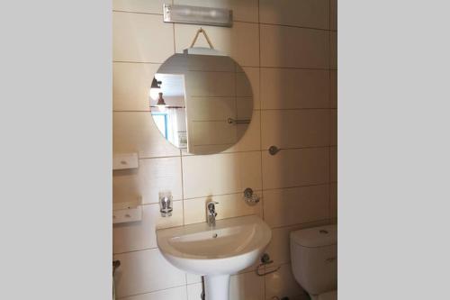 bagno con lavandino, specchio e servizi igienici di Chariklia Traditional House a Città di Alonissos