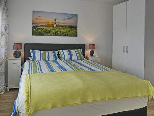 a bedroom with a bed with a yellow blanket on it at Techt bi Strön in Westerland (Sylt)