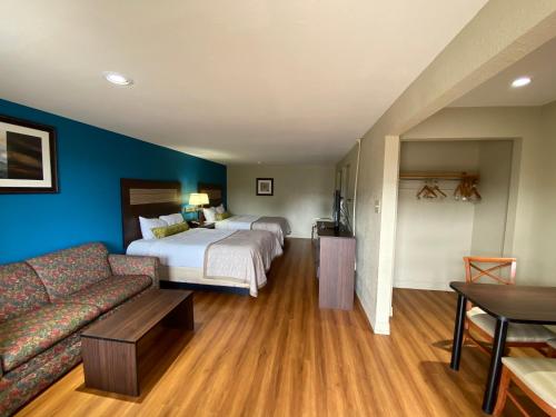a hotel room with a bed and a couch at Stratford House Inn and Suites Temple in Temple