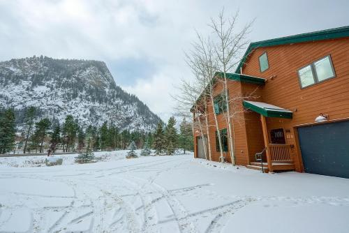 a building in the snow with a mountain in the background at Frisco River Townhomes #D in Frisco