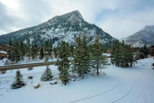 a snow covered mountain with trees and a road at Frisco River Townhomes #D in Frisco