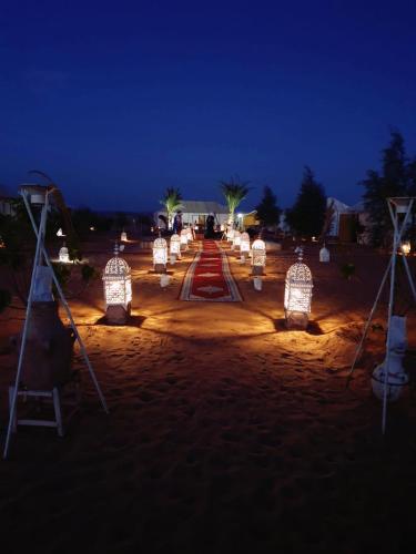 a group of lights on a beach at night at Berber Camp in Merzouga