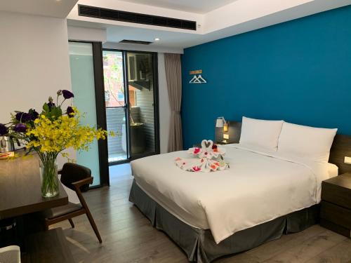 a bedroom with a large bed with a blue wall at Greenight Hotel in Taichung