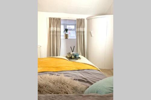 a bedroom with a bed with a yellow and gray blanket at City STAY in Leeds