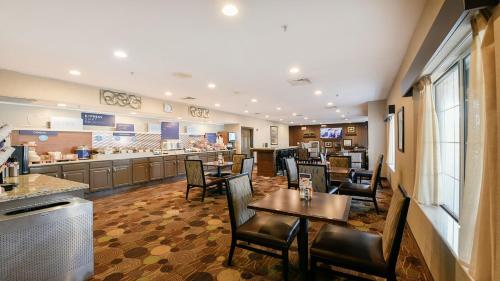a restaurant with tables and chairs and a bar at Holiday Inn Express & Suites Chicago Deerfield Lincolnshire by IHG in Riverwoods