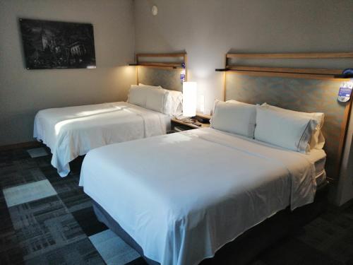 two beds in a hotel room with white sheets at Holiday Inn Express Mexico Reforma by IHG in Mexico City