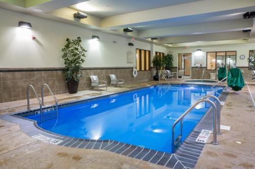 a pool in a hotel with blue water at Holiday Inn Hotel & Suites Bloomington Airport by IHG in Bloomington