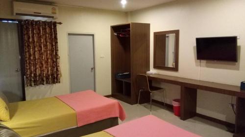 a room with a bed and a desk and a television at ศรีกรุงดีลักซ์โฮเตล in Phra Nakhon Si Ayutthaya