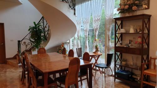 uma sala de jantar com uma mesa de madeira e cadeiras em Beauty Monroe B&B-可包棟-150吋投影-唱歌-夏日玩水-烤肉-電動麻將 em Wujie