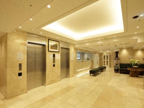 a large lobby with a waiting room with a couch at Check in Shijokarasuma in Kyoto