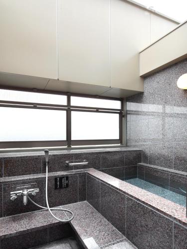 a bathroom with a bath tub with a hose at Check in Shijokarasuma in Kyoto
