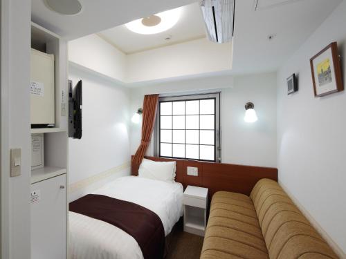 a hotel room with two beds and a couch at Check in Shijokarasuma in Kyoto