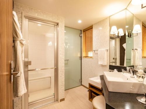 a bathroom with a sink and a shower and a toilet at Solaria Nishitetsu Hotel Kagoshima in Kagoshima