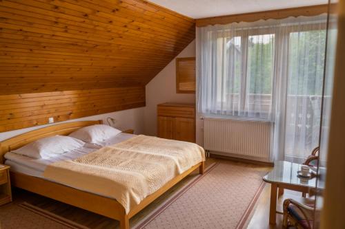ein Schlafzimmer mit einem Bett und einem großen Fenster in der Unterkunft APARTMA PR TAVČARJU in Zgornje Gorje