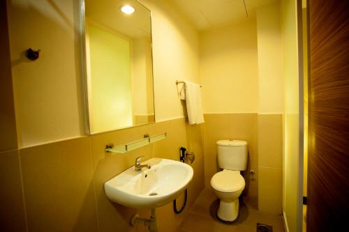 a bathroom with a sink and a toilet and a mirror at Mangga Boutique Hotel in Seri Kembangan
