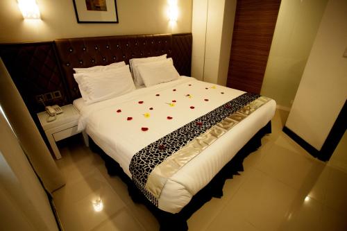 a bedroom with a large bed with flowers on it at Mangga Boutique Hotel in Seri Kembangan