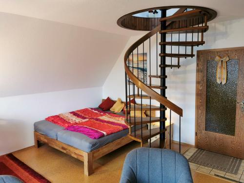 a bedroom with a bed and a spiral staircase at Haus-Deichläufer in Westerdeichstrich