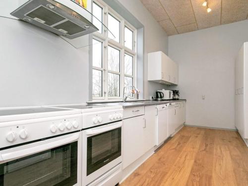 a kitchen with white appliances and a large window at 26 person holiday home in Roslev-By Traum in Åsted