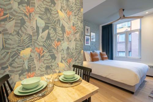 een slaapkamer met een bed en een tafel met borden erop bij The Light Blue Parrot in Antwerpen