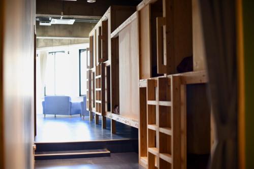 a room with wooden cabinets and a room with a chair at Guesthouse & Lounge FARO iwaki in Iwaki