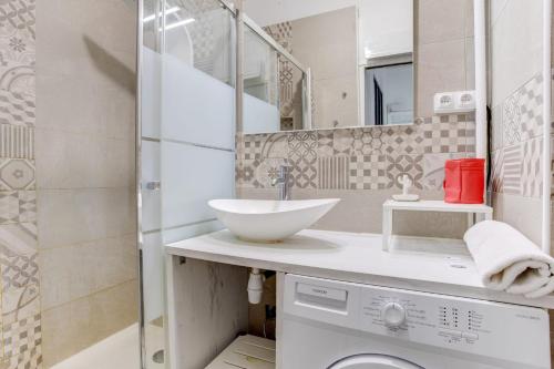 une salle de bain avec un lavabo et une machine à laver dans l'établissement Marseille - hyper centre- Docks Joliette - maxi 8p, à Marseille