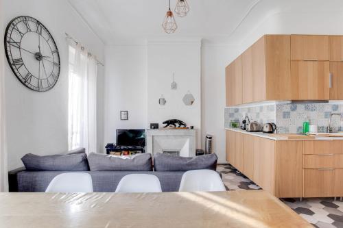 un salon avec un canapé et une horloge au mur dans l'établissement Marseille - hyper centre- Docks Joliette - maxi 8p, à Marseille