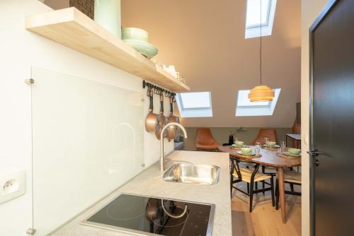 a kitchen with a sink and a table in it at SHWAY - The Pink Pigeon in Antwerp