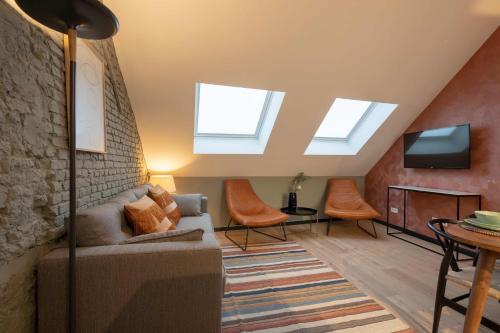 ein Wohnzimmer mit Oberlichtern, einem Sofa und einem TV in der Unterkunft Pink Pigeon in Antwerpen