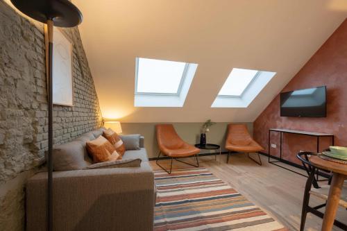 a living room with skylights and a couch and a tv at SHWAY - The Pink Pigeon in Antwerp