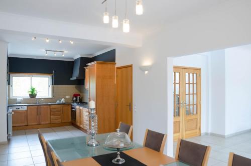 a kitchen with a table and chairs and a kitchen with at Villa Montanha, 4 Bedroom Villa, with swimming pool, loungers and alfresco dining, 10 min walk to the beautiful Praia da Luz Beach, Shops, Bars and Restaurants! in Luz