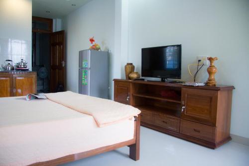 ein Schlafzimmer mit einem Bett und einem TV auf einer Kommode in der Unterkunft Timeless Apartment in Nha Trang