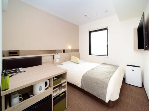 1 dormitorio con 1 cama y escritorio con TV en Super Hotel Tokyo Hamamatsucho en Tokio