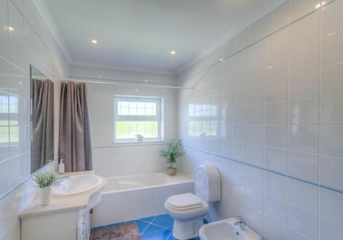 a bathroom with a tub and a toilet and a sink at Villa Montanha, 4 Bedroom Villa, with swimming pool, loungers and alfresco dining, 10 min walk to the beautiful Praia da Luz Beach, Shops, Bars and Restaurants! in Luz