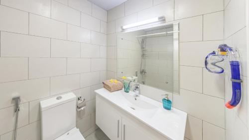 a white bathroom with a sink and a mirror at KSK Homes Hotel Dubai Academic City in Dubai