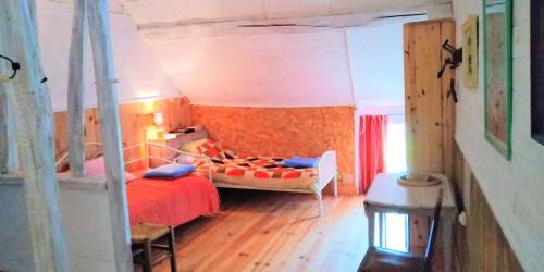 um quarto com uma cama vermelha num quarto em Ferme de l'Art Rural et Populaire em Maillot