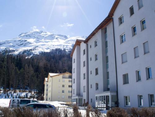 a group of buildings in front of a snow covered mountain at swissme - 100qm - Balkon - 2 Bäder - Parkplatz - Fußbodenheizung in St. Moritz