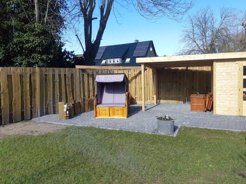 a backyard with a fence and a shed at Nordlichthuus in Tönning